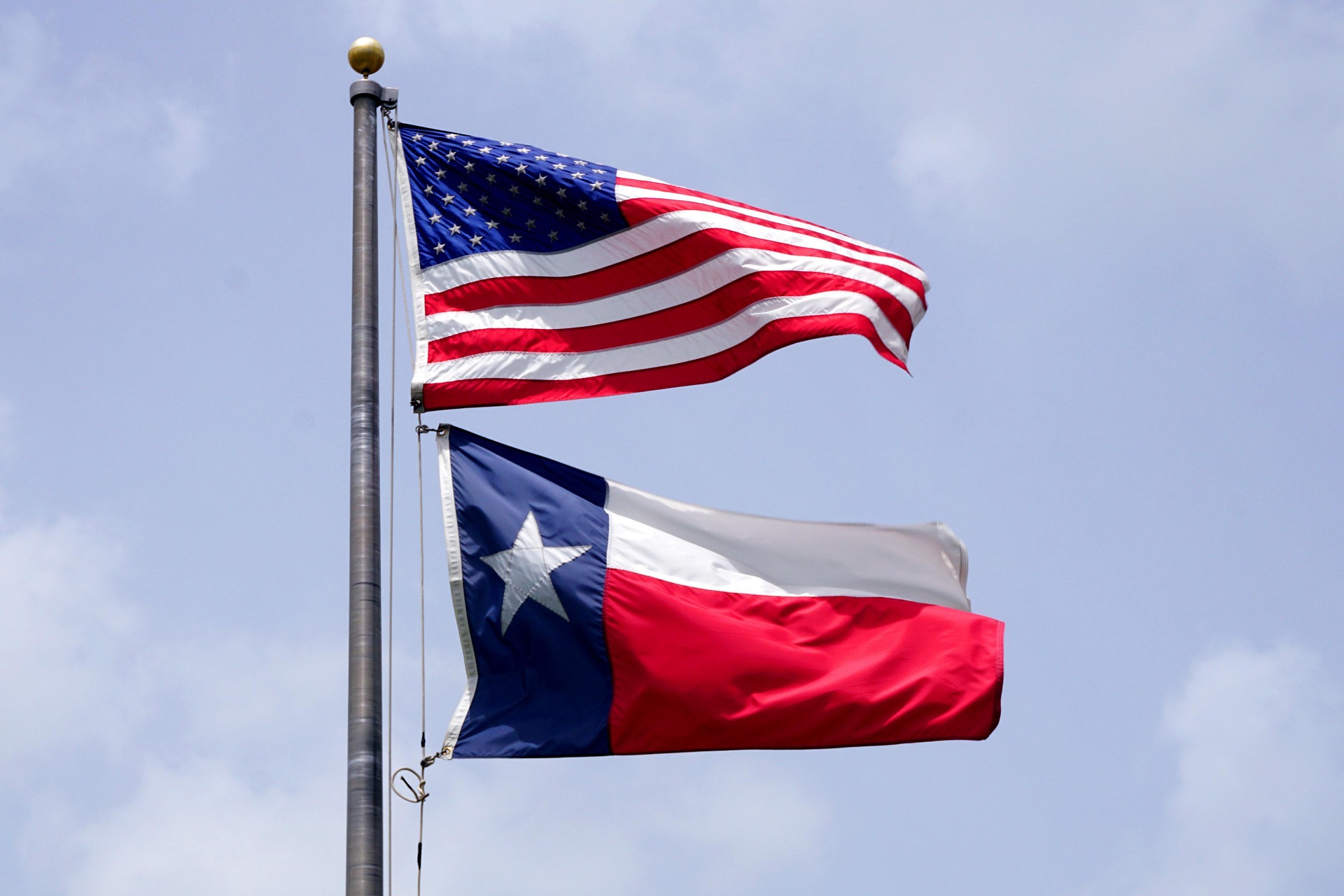Texas and United States flags flying together